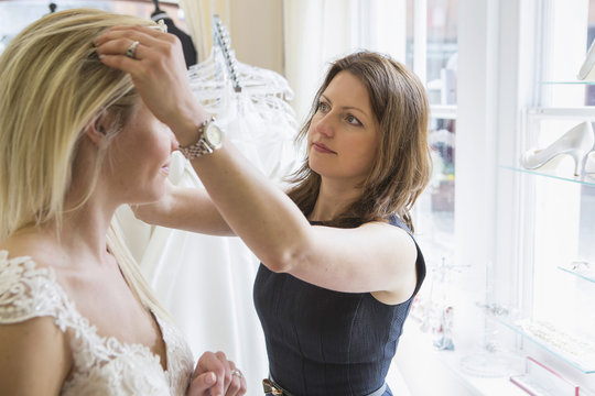 Sales clerk arranging wreath in hair of female customer