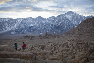 Obraz premium A couple hiking in the Alabama Hills at the foot of the Sierra Nevada Mountains near Lone Pine, California.