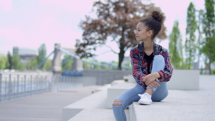 Portrait of a young african american woman wearing checkered shirt, outdoors.