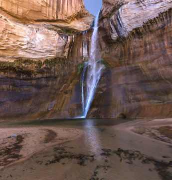 Lower Calf Creek Falls Reflection - A breath-taking, beautiful, cool, 130 foot desert waterfall at the end of a canyon grotto with a reflection in the transparent pond. Boulder, Utah.
