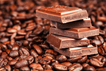Broken chocolate bar and spices on wooden table.