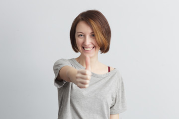 Red-haired girl with freckles showing a thumbs up