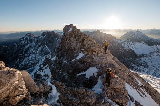 Two mountaineers climbing on mountain peak in European Alps