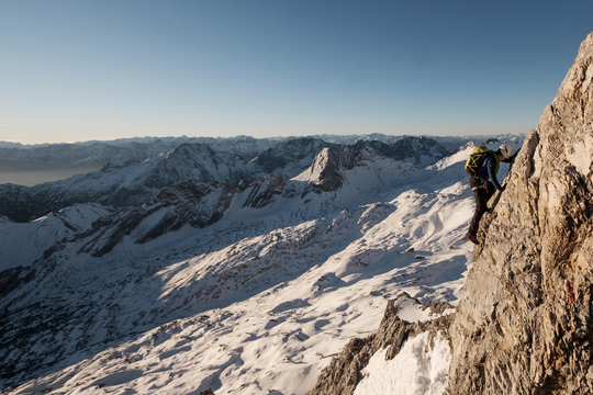 Lone mountaineer climbing steep wall in European Alps