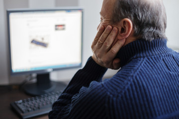 Man looking for information on the Internet. Retired develops computer technology at home