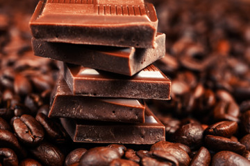 Broken chocolate bar and spices on wooden table.