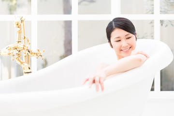Obraz na płótnie Canvas young asian woman relaxing in bathtub