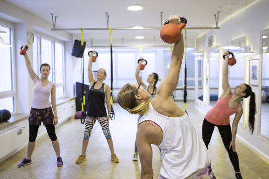 Women in exercise class practicing with kettlebells