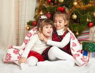 Fototapeta na wymiar two girls portrait in christmas decoration, winter holiday concept, decorated fir tree and gifts