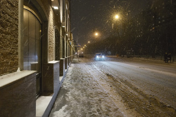 Fototapeta na wymiar The snowfall and blizzard in the night city