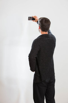 Ein junger Mann macht ein Selbstportrait mit seinem Smartphone