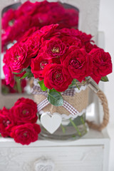 Beautiful red roses .Lovely bunch of flowers .Beautiful fresh roses in a vase decorated with a heart . 