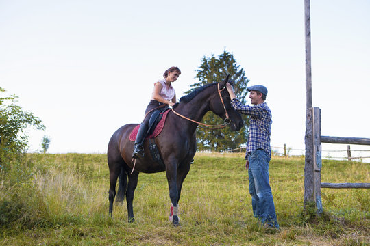 Couple with horse in rural pasture