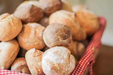 Basket  layed with the towel full of fresh bread rolls