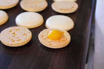 Fresh Orange cream on macaron ready for sandwiching