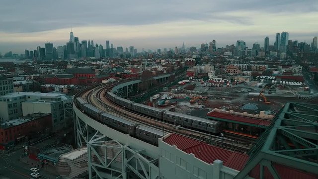 subway trains cross as camera flies over track towards Manhattan