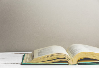 Open book on wooden background. Back to school. Copy space. Toned retro image