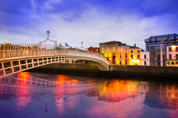 Ha'penny Bridge of the River Liffey in Dublin Ireland in the evening with lights and reflections