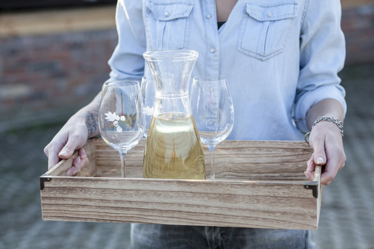 Woman serving white wine on tray