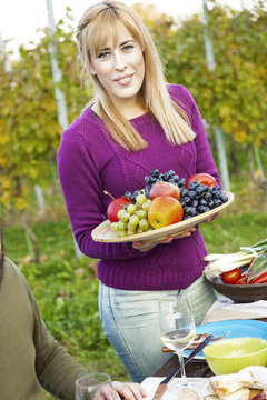 Young woman with a large fruit plate on garden party