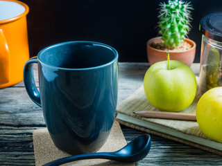 Coffee and apple on the table. During breaks eat fruit and a coffee is a good thing.