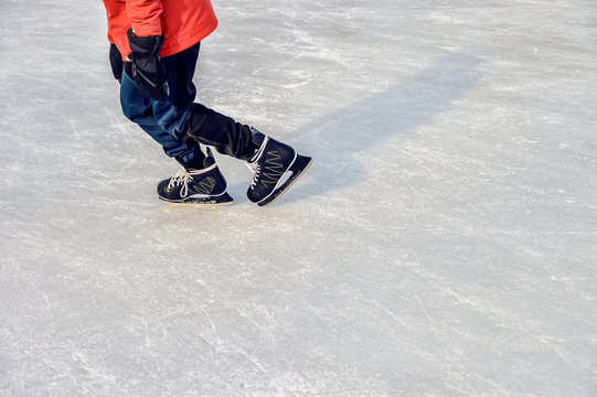 Close-up of ice skater's feet on ice rink