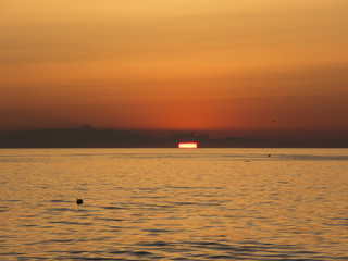 Fiery sunrise at Italian beach. Summer season. Emilia Romagna region. Adriatic sea. Italy