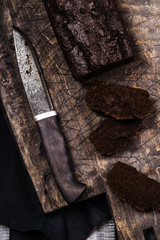 Vegan avocado chocolate cake sliced on an old wooden cutting board. Healthy dessert. Selective focus 