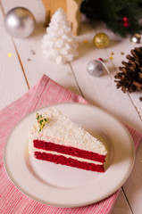 Christmas cake on plate on red fabric on wood background and dec