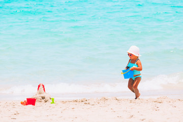 cute little girl play with sand on beach