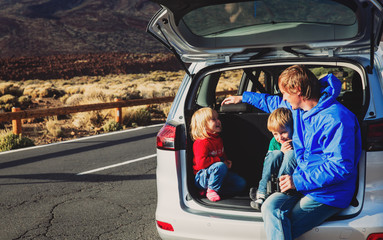 family travel by car- happy father with kids on road
