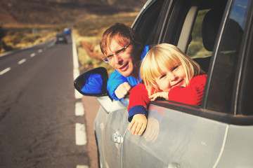 family travel by car- happy father with little daughter driving in mountains