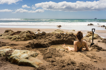 Naklejka premium Woman sitting in hot water thermal pool in Hot Water beach