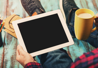 Man holding tablet with copy space and cup of coffee