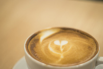 Latte art coffee over wooden background