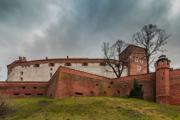 Castle walls against the background of the dark cloudy sky. Poland. Krakow. Wawel