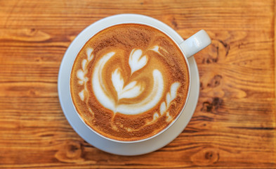 Big cup of cappuccino on a wooden background