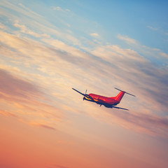 Fototapeta na wymiar Airplane taking off at the sunset sky