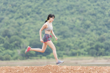 runner - woman running outdoors training for marathon run. Beautiful fit and asian fitness.