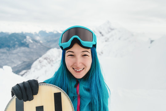 Cheerful snowboarder in winter mountains