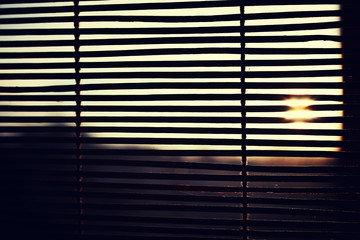 sun is shining through the wood blinds