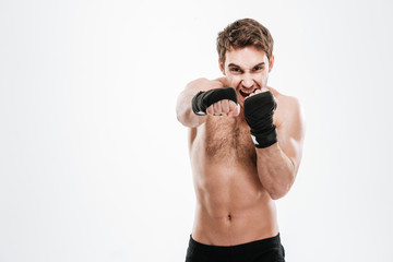 Fototapeta na wymiar Agressive young man boxer make boxing exercises