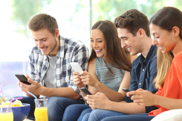 Happy friends using their mobile phones