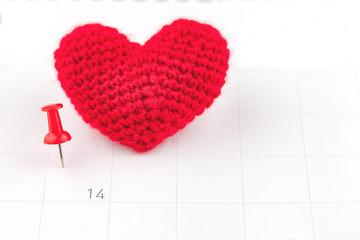 Pushpins on calendar and red heart