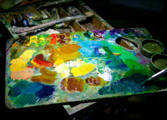 Brushes and artist's palette closeup. Composition on a dark background. Selective focus