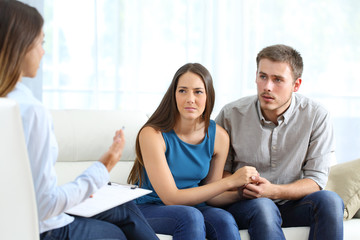 Worried couple listening to marriage counselor