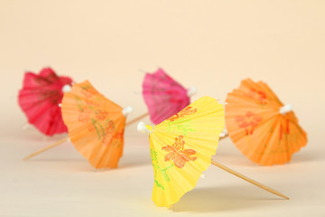 Multi-colored cocktail umbrellas on a light background.
