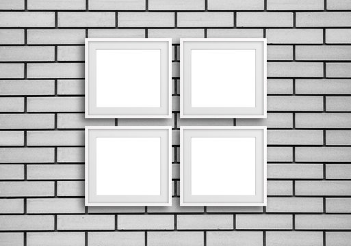 Fototapeta Group of  four white photo frames on grey bricks wall, gallery style design mock up