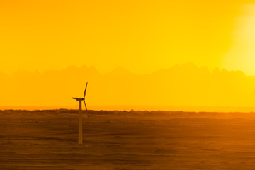Large wind turbines in the desert against mountains