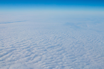 Cloudscape. Blue sky and white clouds. Sunny day. Cumulus cloud. View from the airplane